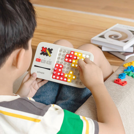 Copil care așază o piesă pe tabla GiiKER Super Blocks