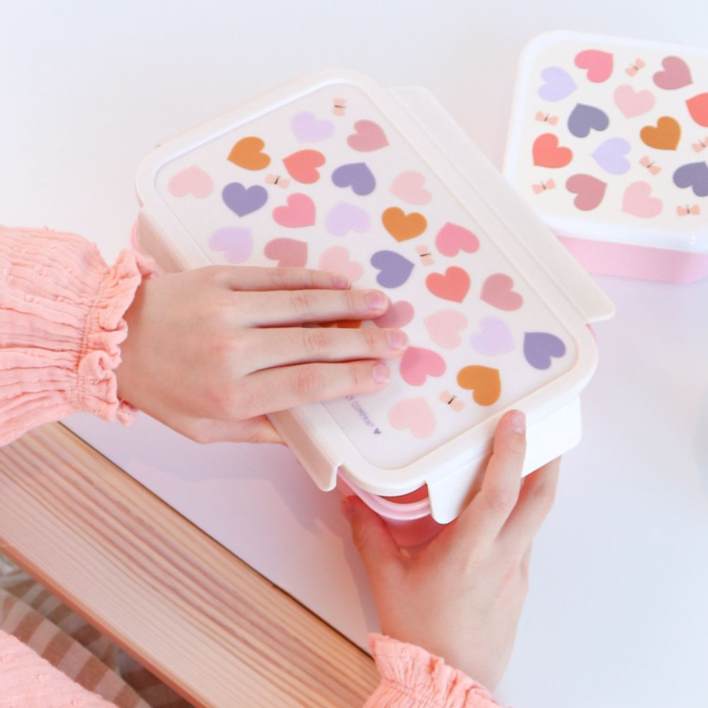 Copil deschizând cutia sandwich Hearts din inox cu alimente în interior